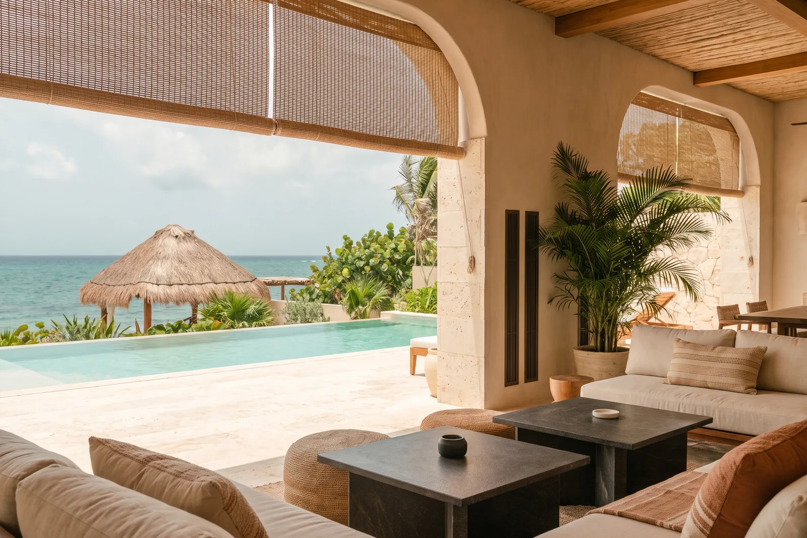 Interior de un hotel boutique caribeño con clima discreto y silencioso, alberca y mar al fondo.